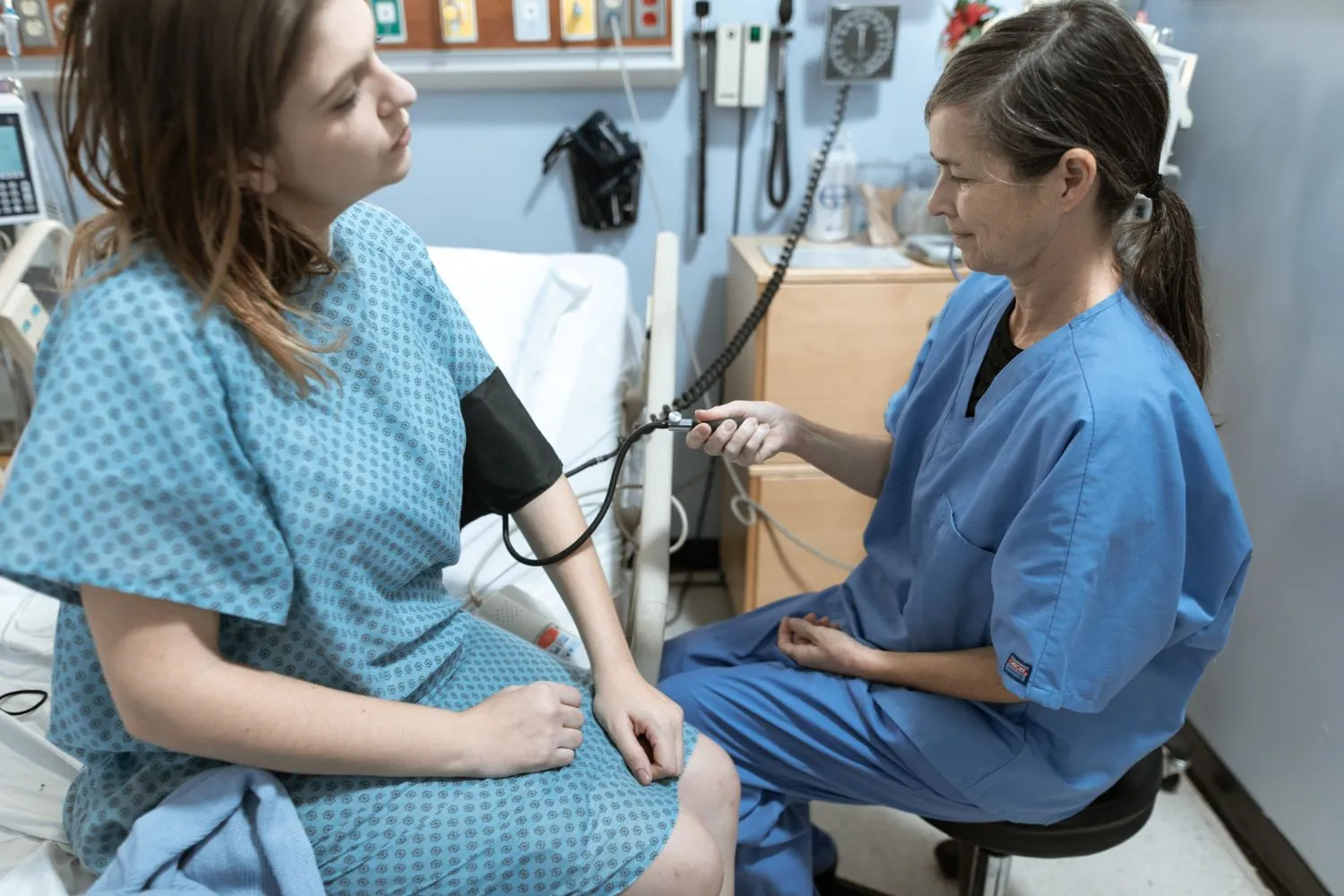 Pflegekraft betreut lächelnd eine Patientin